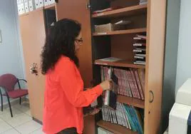 Nieves Fernández colocando los antiguos libros del Registro Civil de Renedo de Esgueva.