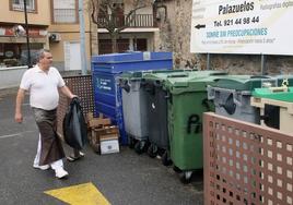 Un vecino de Palazuelos de Eresma deposita sus residuos en un contenedor.