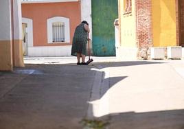 Una mujer barre una calle de Valdestillas, en una imagen de archivo.