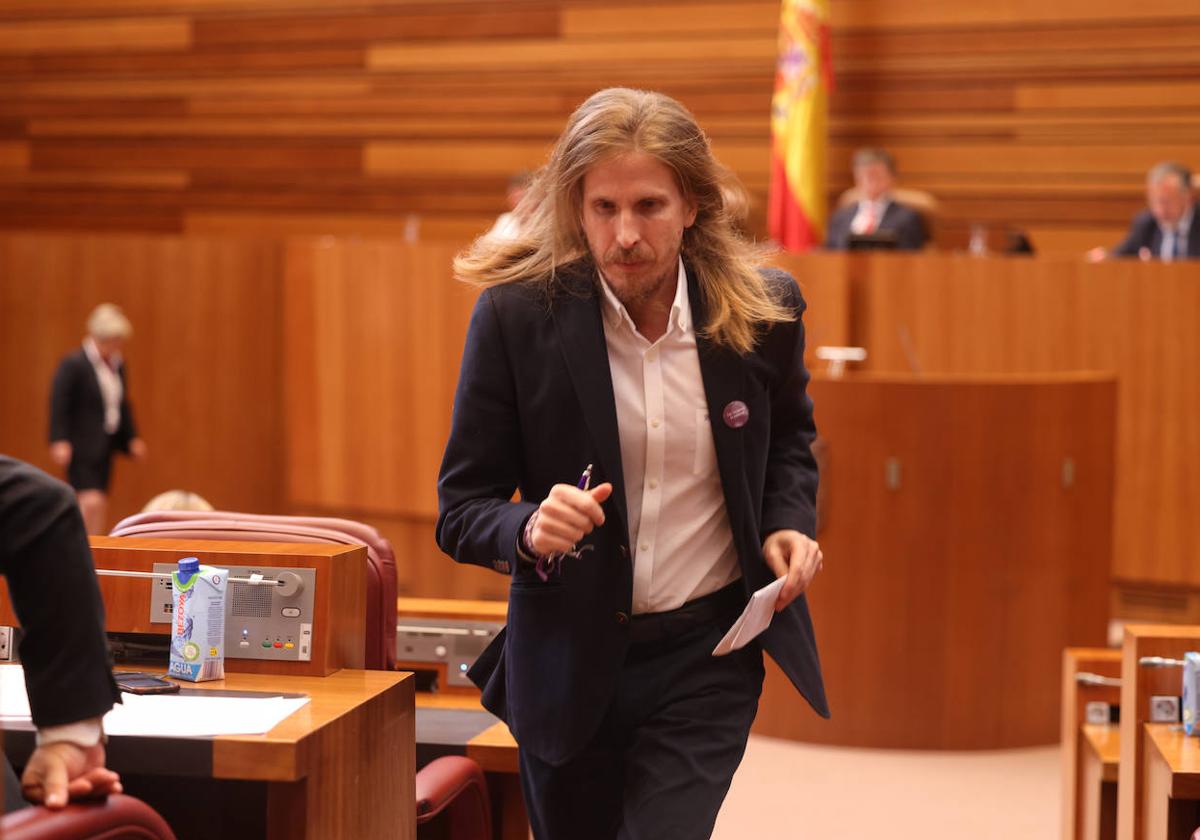 Pablo Fernández, procurador de Podemos, vuelve a su escaño en las Cortes de Castilla y León tras intervenir en un pleno.