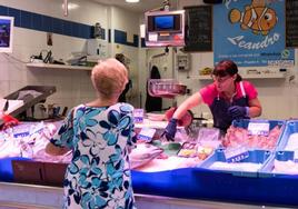 Una mujer compra en una pescadería del mercado de las Delicias.