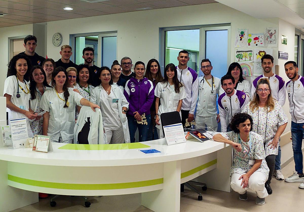 Jugadores y jugadoras del Real Valladolid y UEMC posan junto a profesionales sanitarios durante la visita.
