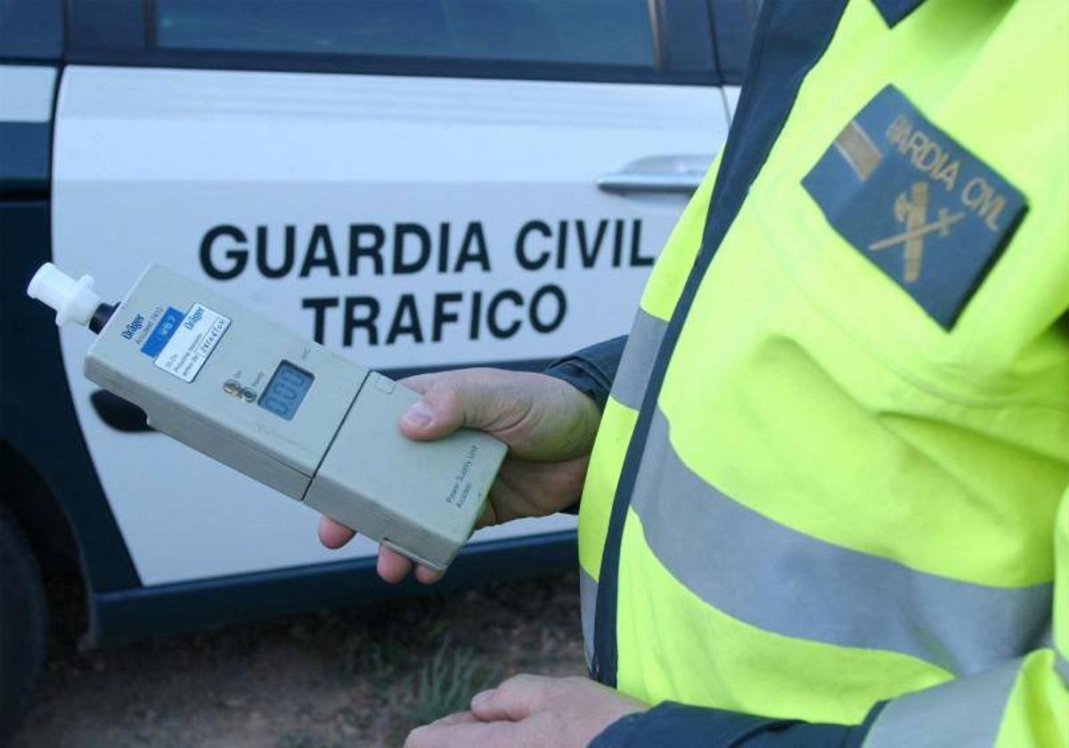 Un guardia, con un alcoholímetro preparado para un control.