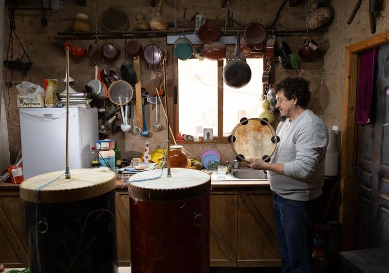 Toño Clavel, en su taller, con una pandereta y dos zambombas hechas por él.