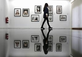 Una mujer observa varios de los retratos en la sala del Teatro Zorrilla.