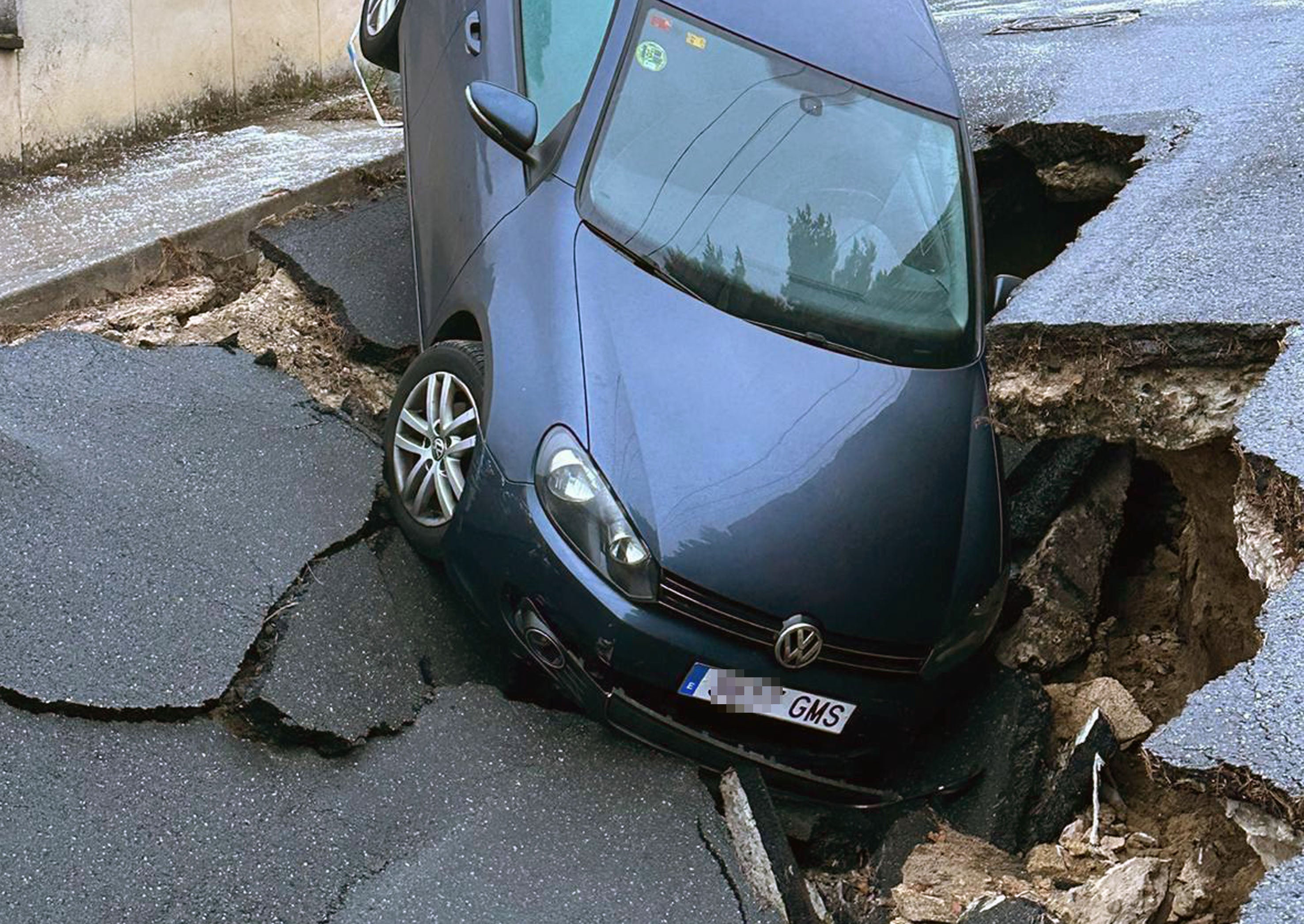 Vehículo en el socavón de la calle Menacho de San Rafael.