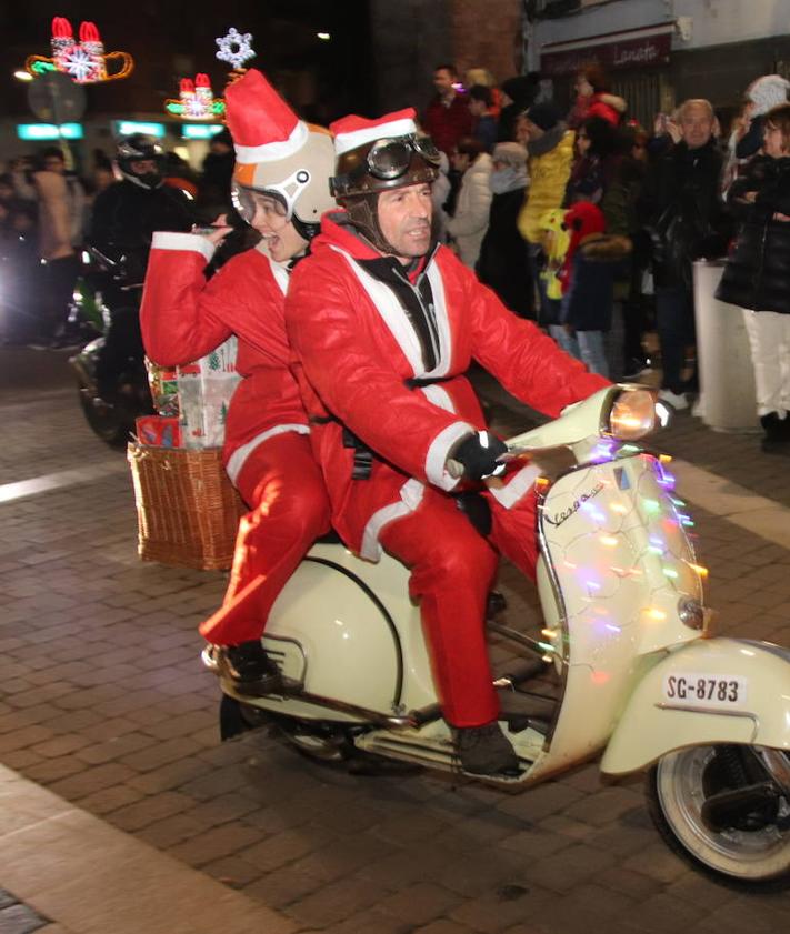 Imagen secundaria 2 - Arriba, Papá Noel recorre Cuéllar sobre su trineo tirado por unos renos; abajo, un grupo de escolares disfrazados de estrellas y a la derecha, participantes en la recepción motera a Santa Claus.