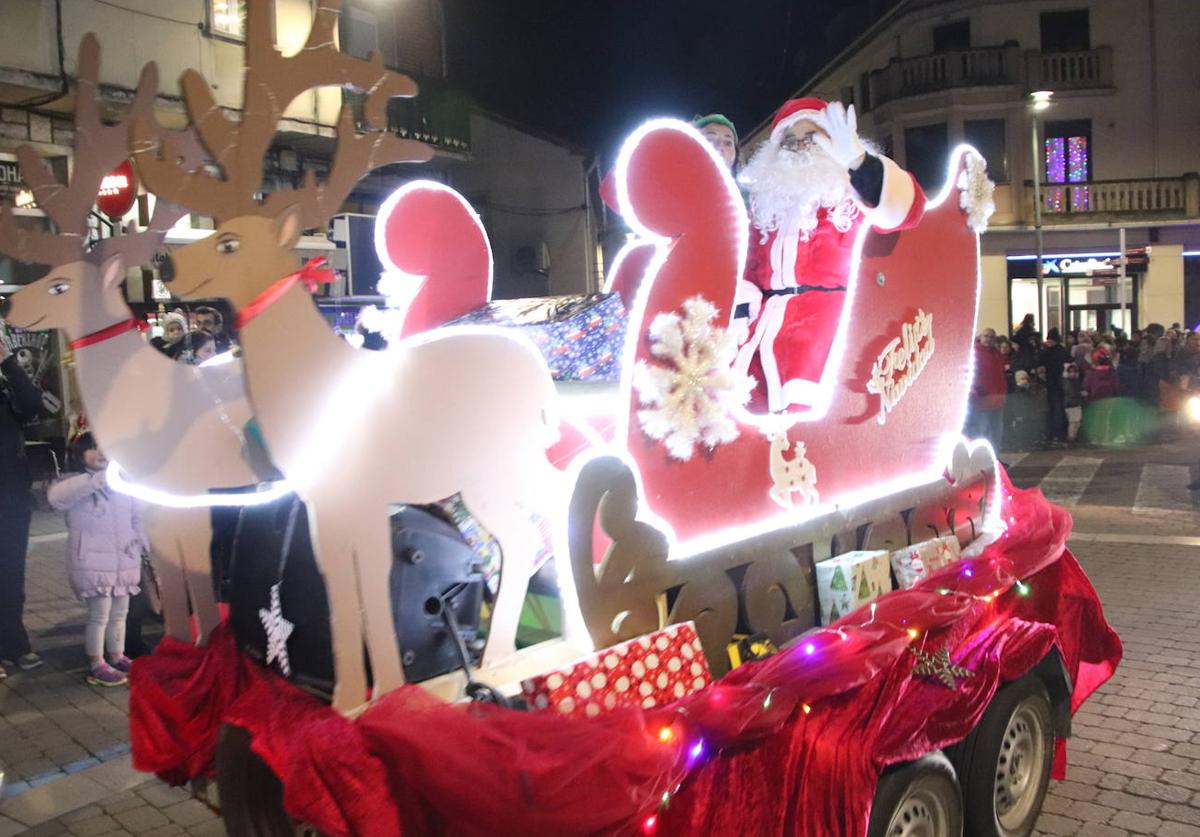 Imagen principal - Arriba, Papá Noel recorre Cuéllar sobre su trineo tirado por unos renos; abajo, un grupo de escolares disfrazados de estrellas y a la derecha, participantes en la recepción motera a Santa Claus.