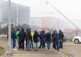 Los empleados de Cascajares esperan ante la fábrica incendiada.