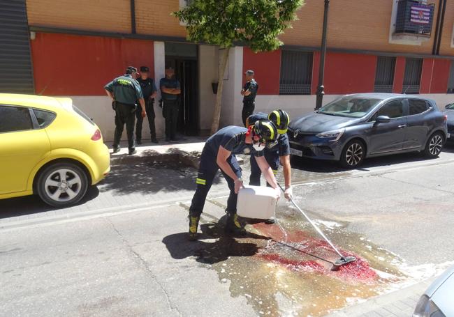 Bomberos limpian la sangre de la calzada de la calle Alfredo Martín de Santovenia.