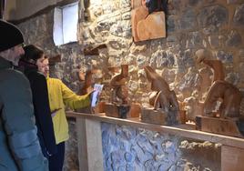 Varios visitantes observan las tallas de madera de 'Ursi', este viernes en Aguilar.