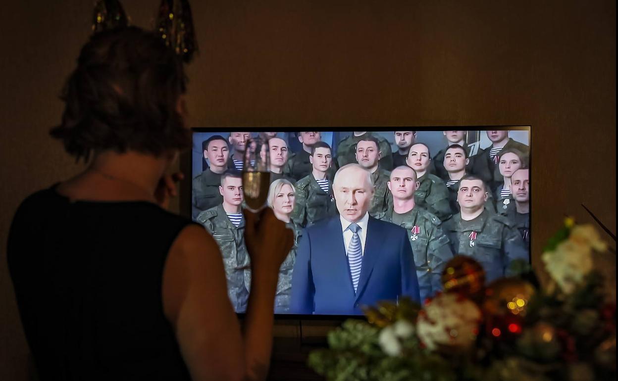 Una mujer escucha el discurso de Año Nuevo de Putin, a la nación en su casa en Moscú.