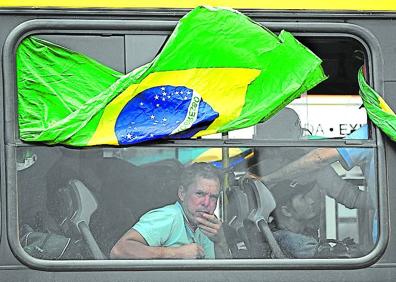 Imagen secundaria 1 - Miembros de seguridad del Palacio Presidencial de Planalto inspeccionan oficinas destruidas. Simpatizantes de Bolsonaro detenidos, trasladados en autobuses. Un partidario de Bolsonaro abandona un campamento frente al cuartel general del Ejército. 