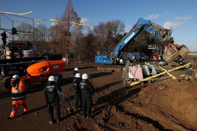 Una excavadora derriba una barrera colocada por los activistas.