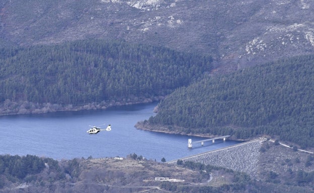 Un helicóptero de la Guardia Civil sobrevuela la sierra de Béjar y Candelario, cerca del embalse de Béjar, En el centro, abajo, la plataforma de Candelario, donde está el puesto de mando avanzado para la búsqueda. 