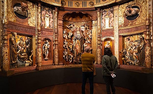 Dos personas, frente a parte del retablo de San Benito, de Alonso Berruguete. 