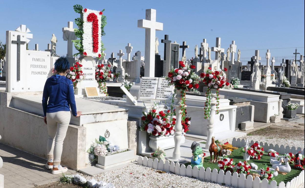 Un a mujer visita una tumba en el cementerio de El Carmen. 