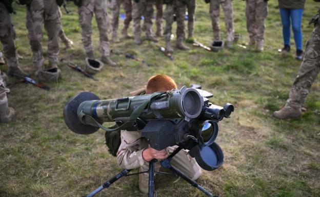 Imagen principal - Arriba, un soldado británico instruye a soldados de Kiev en el uso de Javelin. Abajo, un tanque ruso destrozados y un militar ucraniano disparando un lanzagranadas.