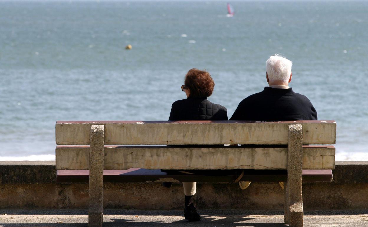 Una pareja de jubilados descansa frente al mar