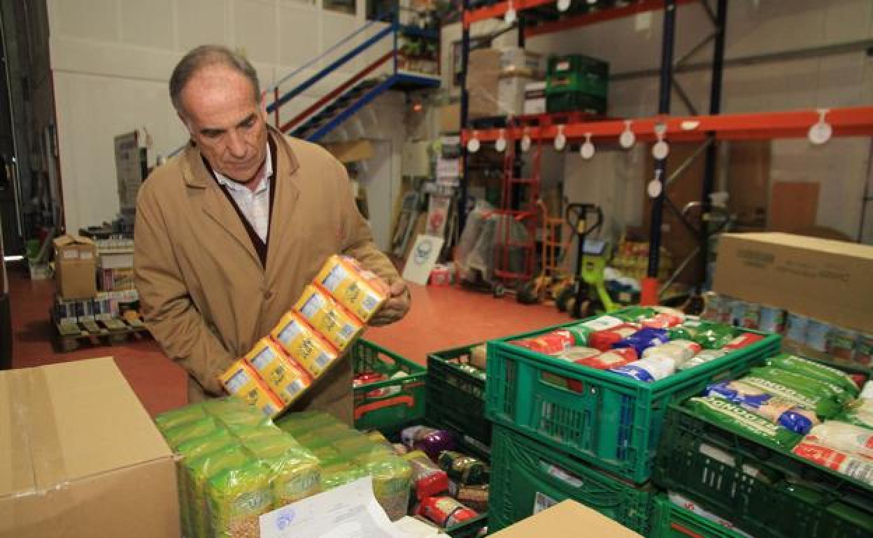 Rufo Sanz coloca algunos de los productos no perecederos en la nave del Banco de Alimentos. 