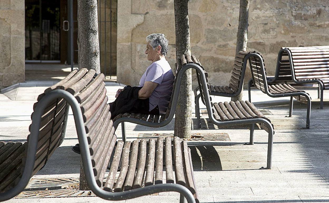 Una mujer mayor descansa en un banco de la localidad zamorana de Fermoselle.