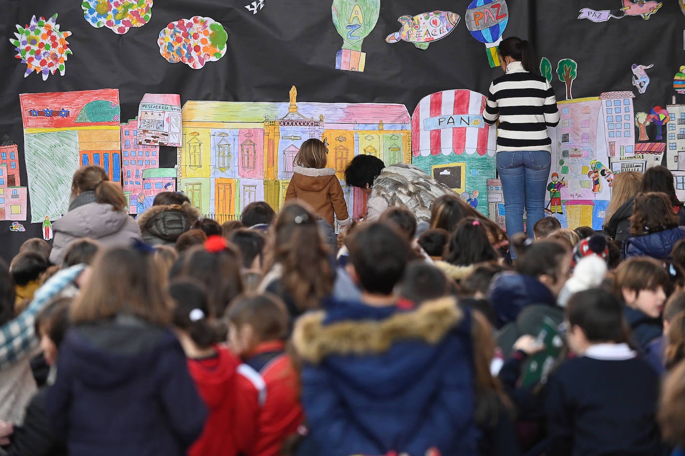 Varios niños y niñas del colegio San José cuelgan pancartas para conmemorar el Día Mundial de la Paz.