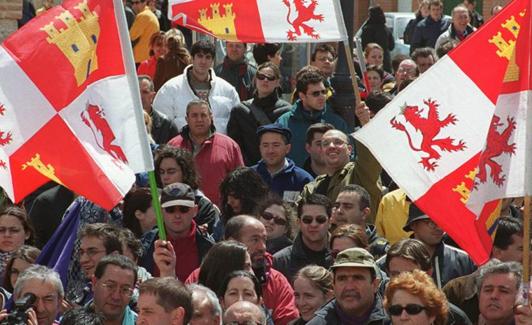 Un grupo de personas enarbolan banderas de Castilla y León en una celebración de Villalar. 