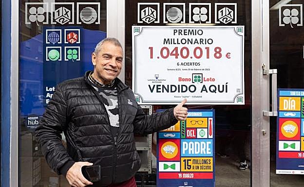 José Manuel González posa junto al cartel en la puerta de su quiosco. 