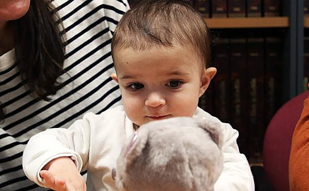 Imagen principal - Arriba, Emma juega con un peluche. Abajo, junto a sus padres a los pies del Acueducto. A la derecha, la bebé baja las escaleras del Postigo con la ayuda de su madre. 