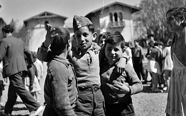 Tres niños delante de un palacio convertido en escuela, en 1937. 