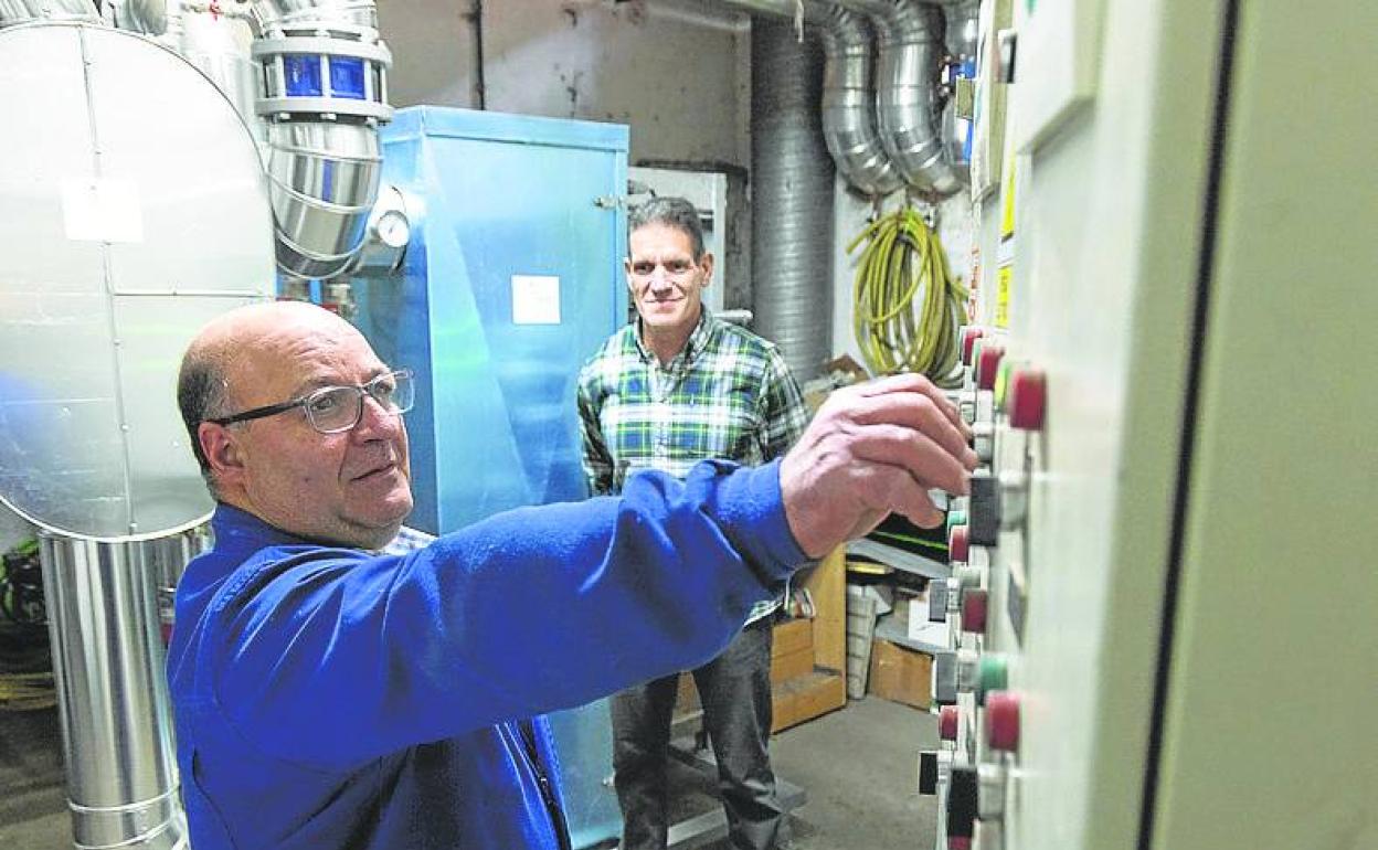 Carlos Fernández y Javier Santander, ante una caldera de biomasa. 