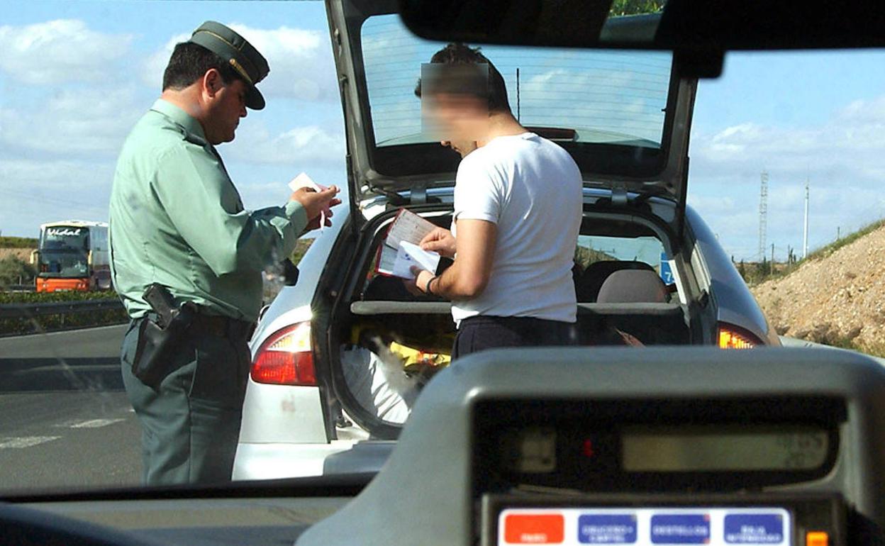 Un agente de la Guardia Civil de Tráfico pone una multa a un conductor.