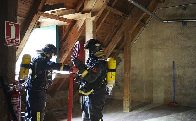 Imagen principal - Arriba, bomberos con una manguera en una de las buhardillas del ala norte de la fortaleza. Abajo, personal sanitario con el trabajador afectado por una hipotética inhalación de humo. Al lado, imagen de la cámara térmica. 