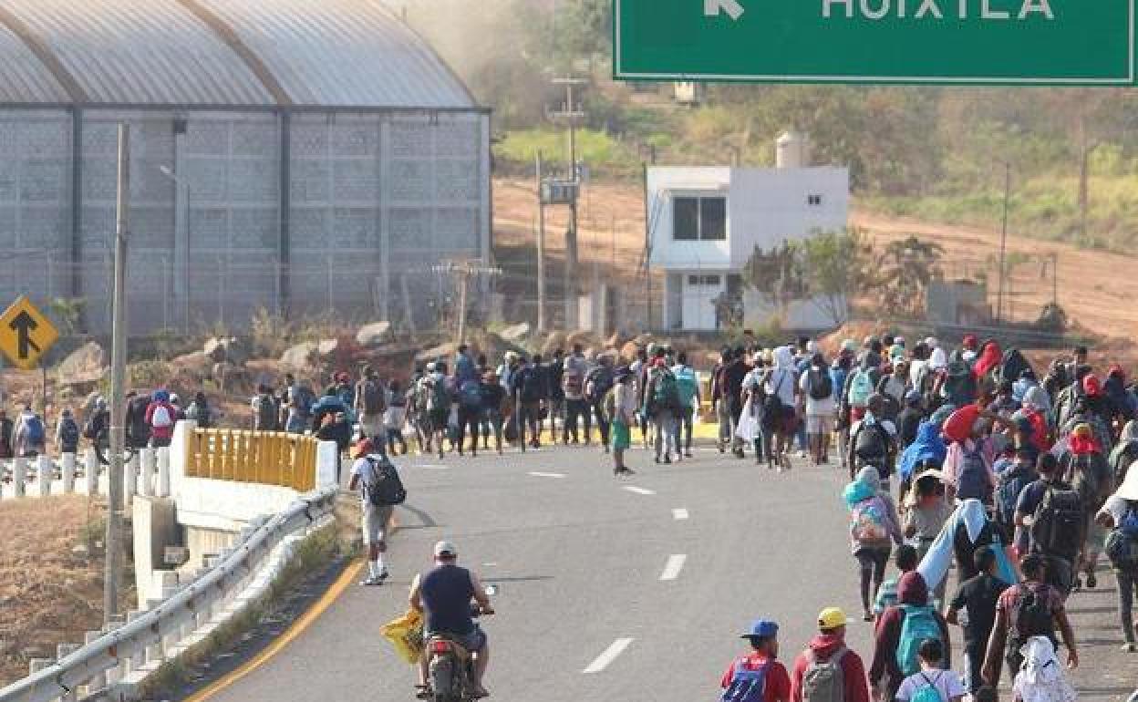 Migrantes caminan por una carretera de la ciudad de Huixtla, en el sur de México, con destino a la frontera con Estados Unidos