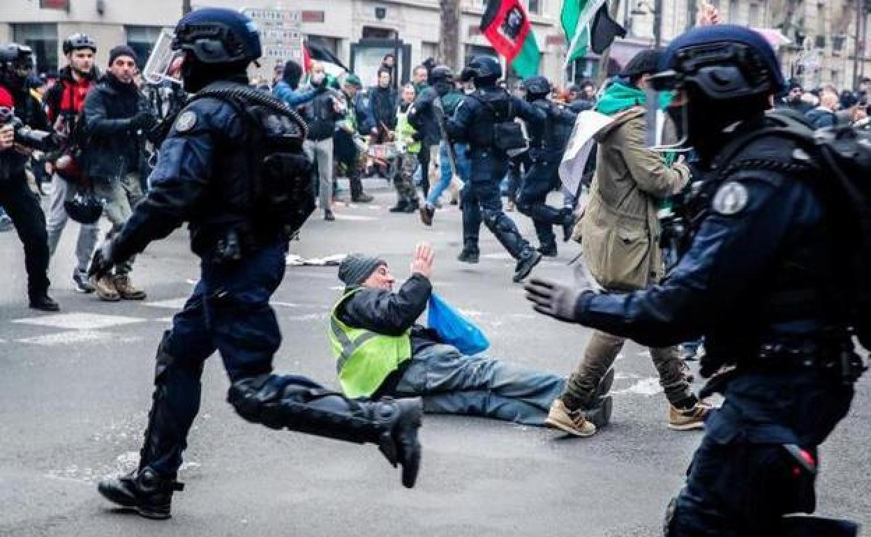 Un manifestante yace en el suelo tras caer durante los incidentes registrados entre radicales y policías en la marcha de París.