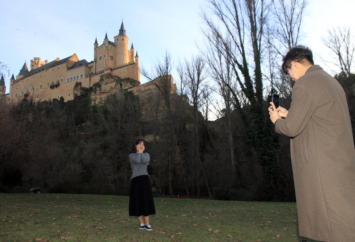 Turistas orientales se fotografían en la pradera de San Marcos con el Alcázar de fondo.