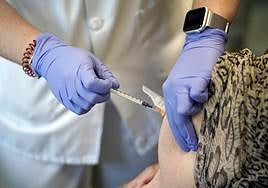 Un enfermero pone una vacuna.