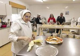 Monjas y voluntarios trbajaan en la elaboración de los roscones de Reyes.