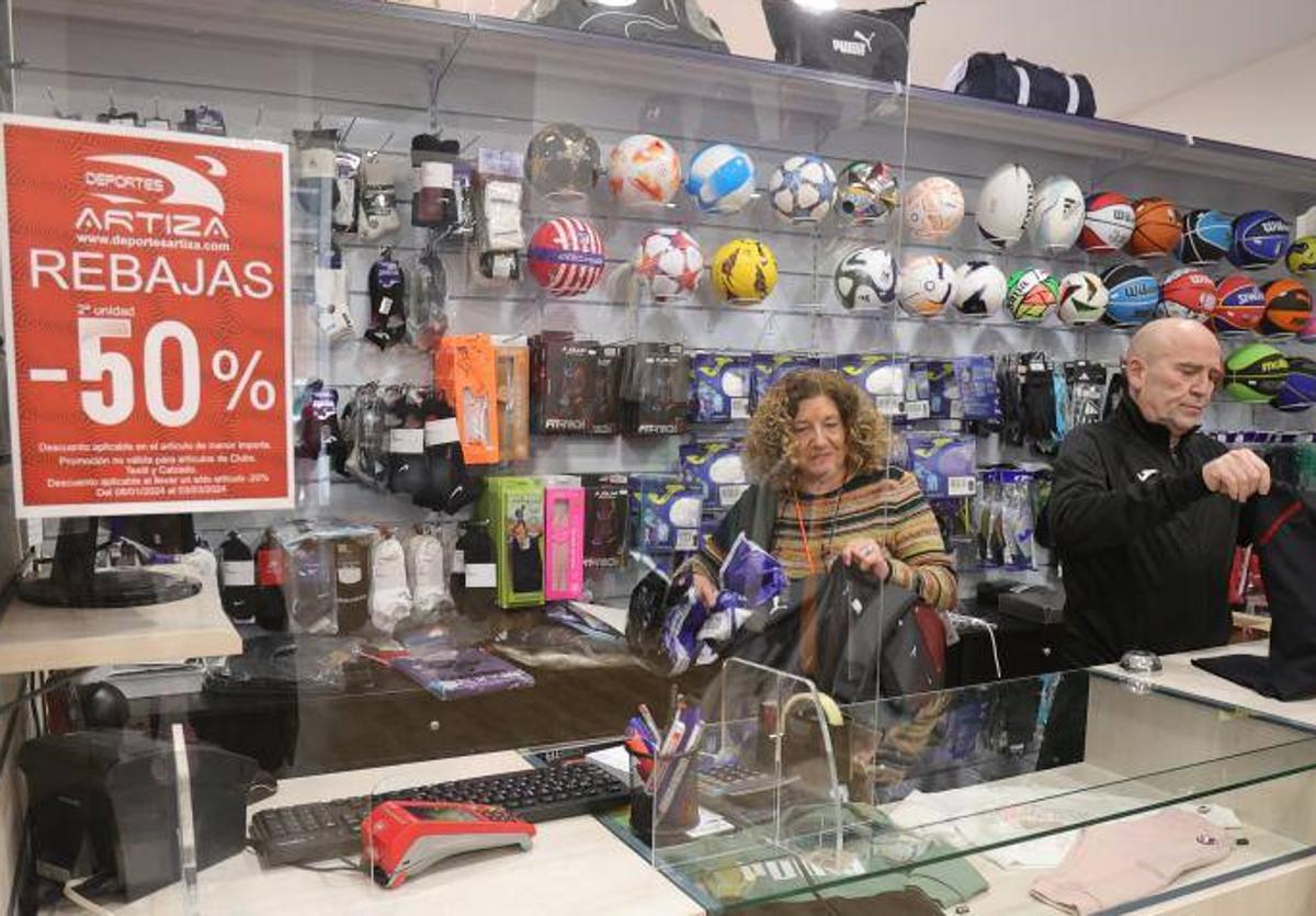 Trabajadores de Deportes Artiza, en Palencia, atienden unas compras el primer de rebajas de invierno.