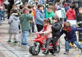 Unos pequeños moteros juegan con la moto que Turismoto ha regalado al colegio García Quintana.