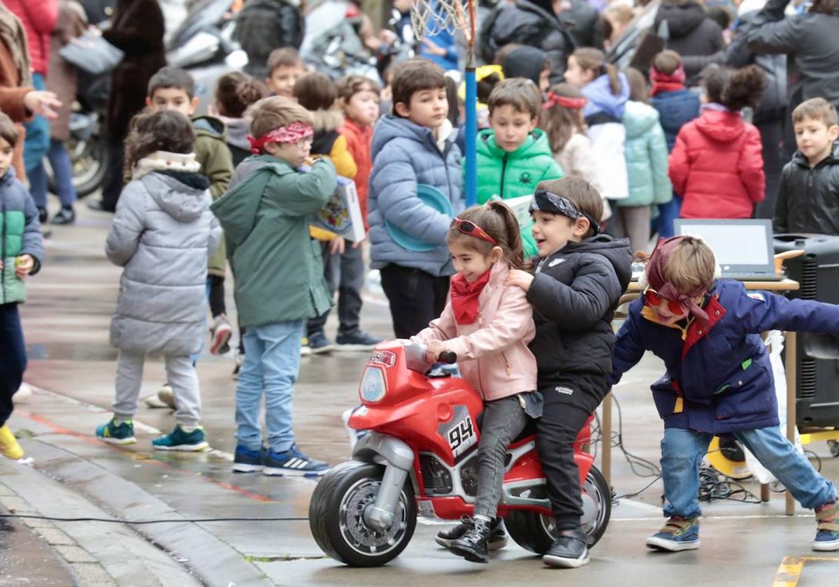 Unos pequeños moteros juegan con la moto que Turismoto ha regalado al colegio García Quintana.