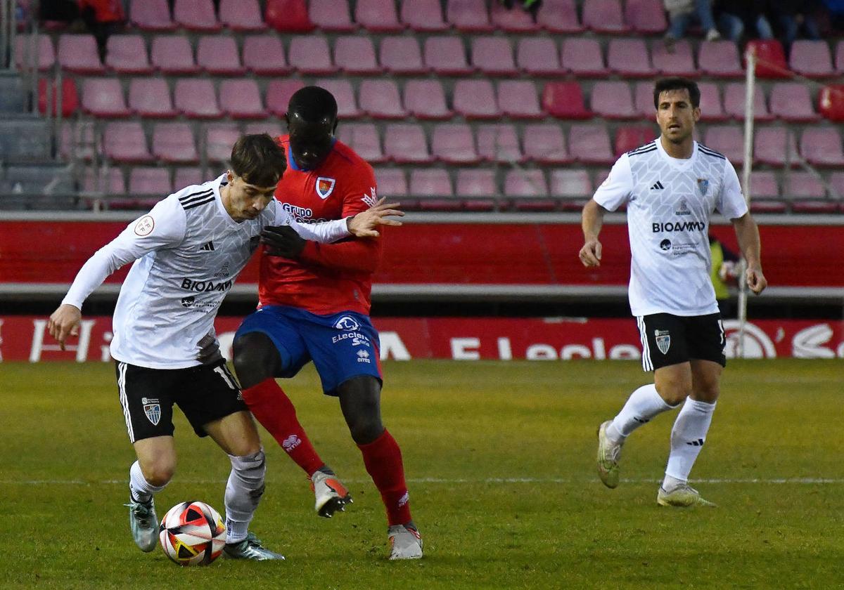 Dani Plomer trata de marcharse de un jugador del Numancia.