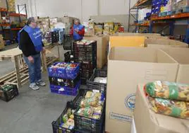 dos voluntarios del Banco de Alimentos de Palencia organizan los alimentos en cajas.