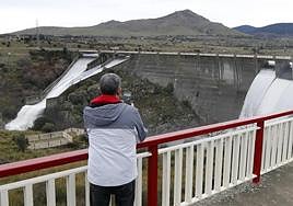 Un hombre hace una fotografía a la suelta de agua en el embalse del Pontón Alto, este martes.