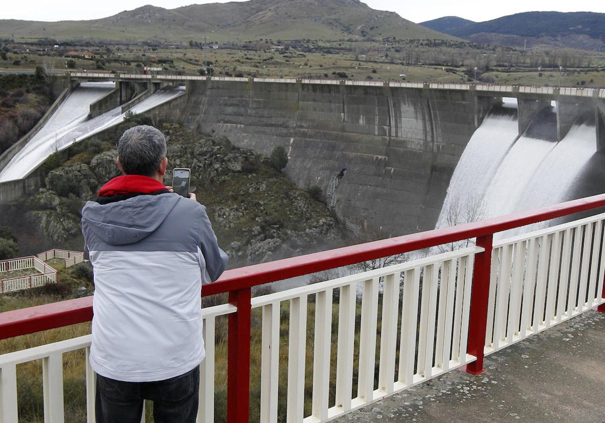 Un hombre hace una fotografía a la suelta de agua en el embalse del Pontón Alto, este martes.