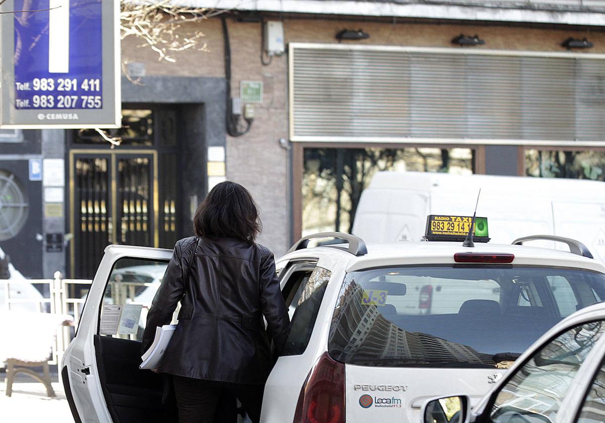 Una mujer se sube en un taxi en la parada de Poniente.