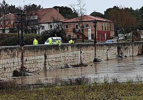 Los operarios intentan despejar los ojos del puente del Cega en Mojados.