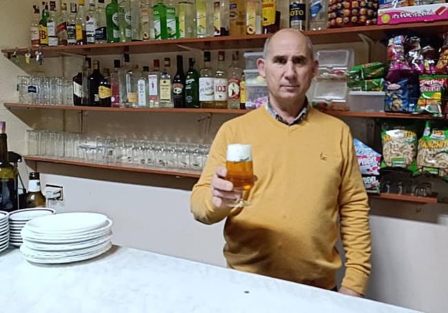 Emilio Gómez, del Centro Social de San Cebrián, sirviendo una caña a un cliente