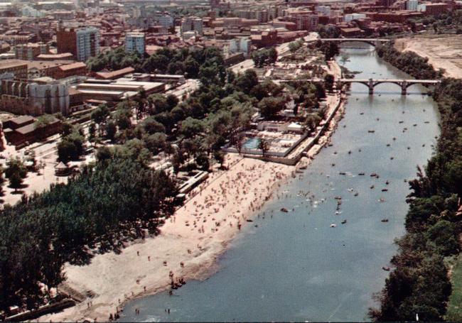 Vista del río lleno de bañistas y de barcas.