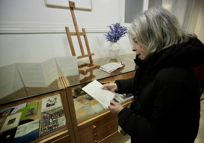 Una visitante observa fotografías y documentos.